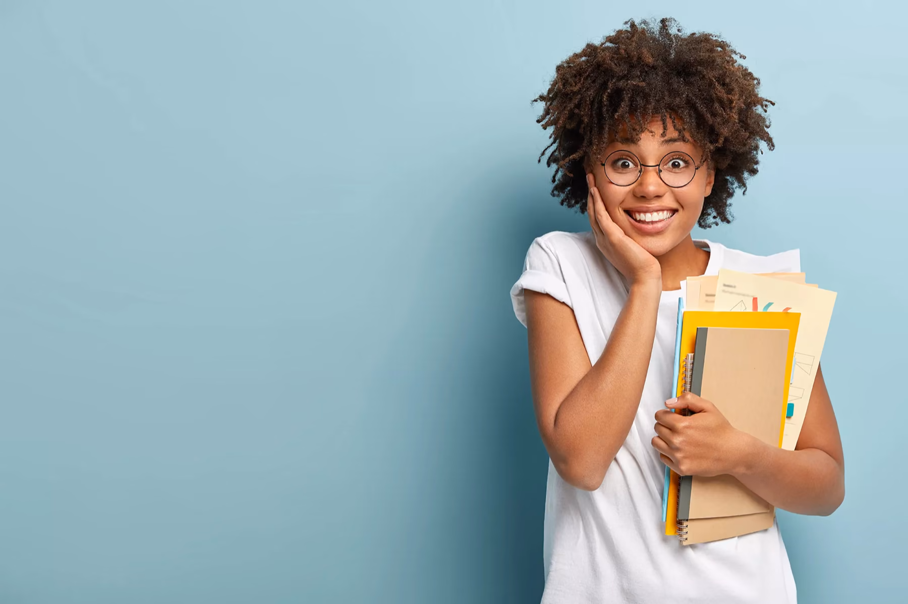 A student holding books, smiling