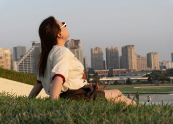 Woman relaxing on a grassy slope in front of the city skyline