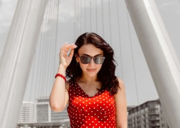 Woman in a red polka dot dress under white arches