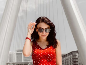 Woman in a red polka dot dress under white arches