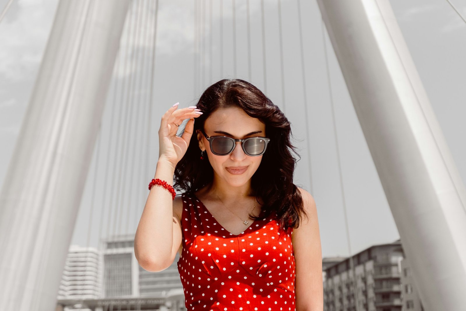 Woman in a red polka dot dress under white arches