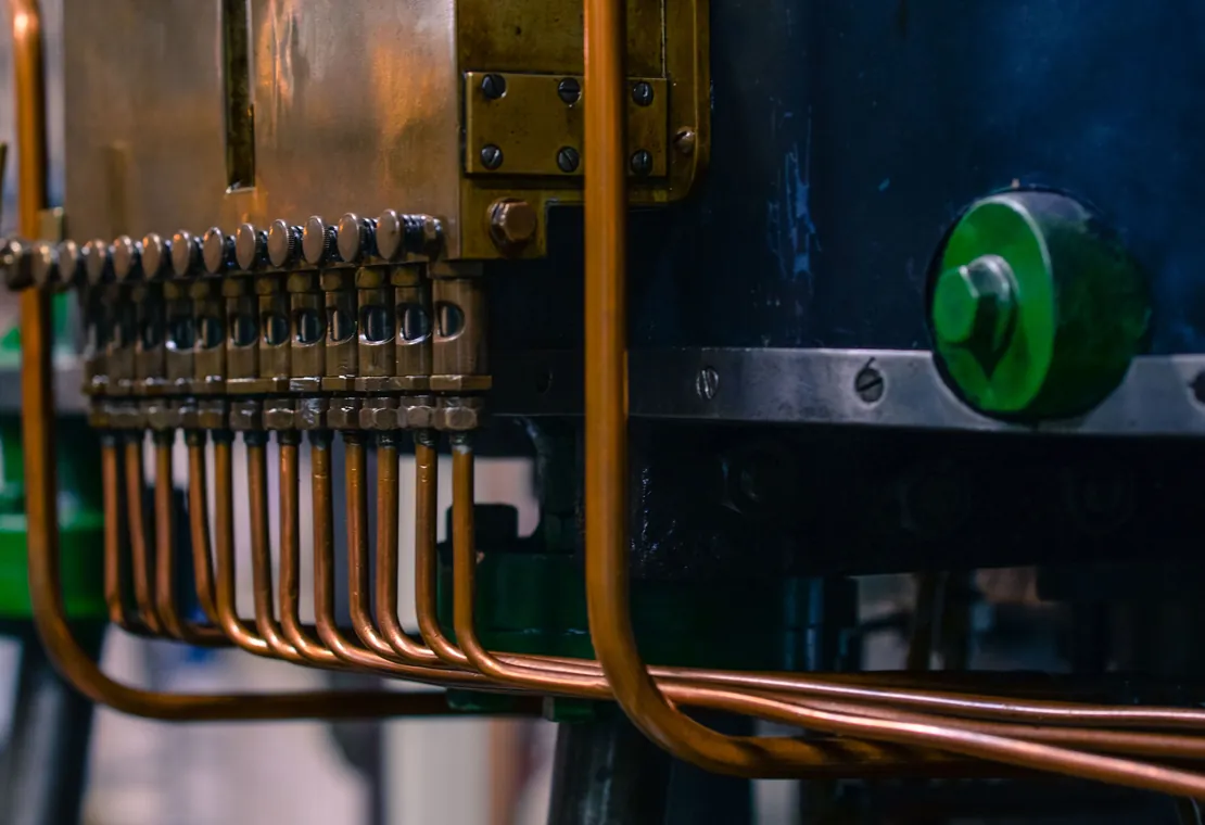 Copper hydraulic lines fanning out from a brass manifold on a press