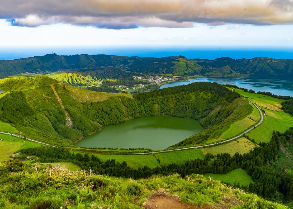 The Sete Cidades caldera on São Miguel: a small green crater lake in front, the larger lake and the village beyond, the Atlantic on the horizon