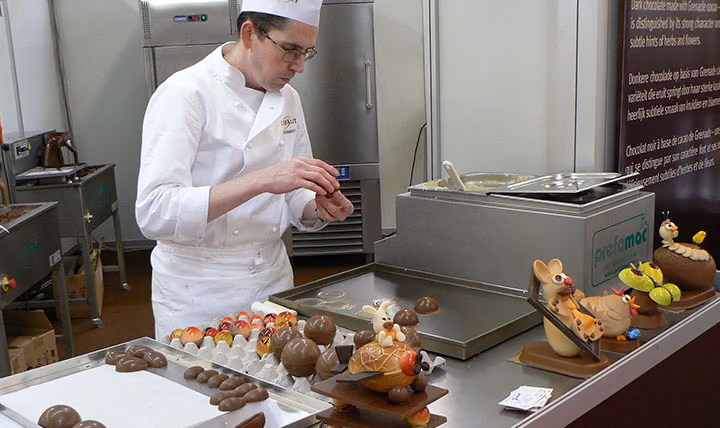 A pastry chef arranging chocolates on a counter
