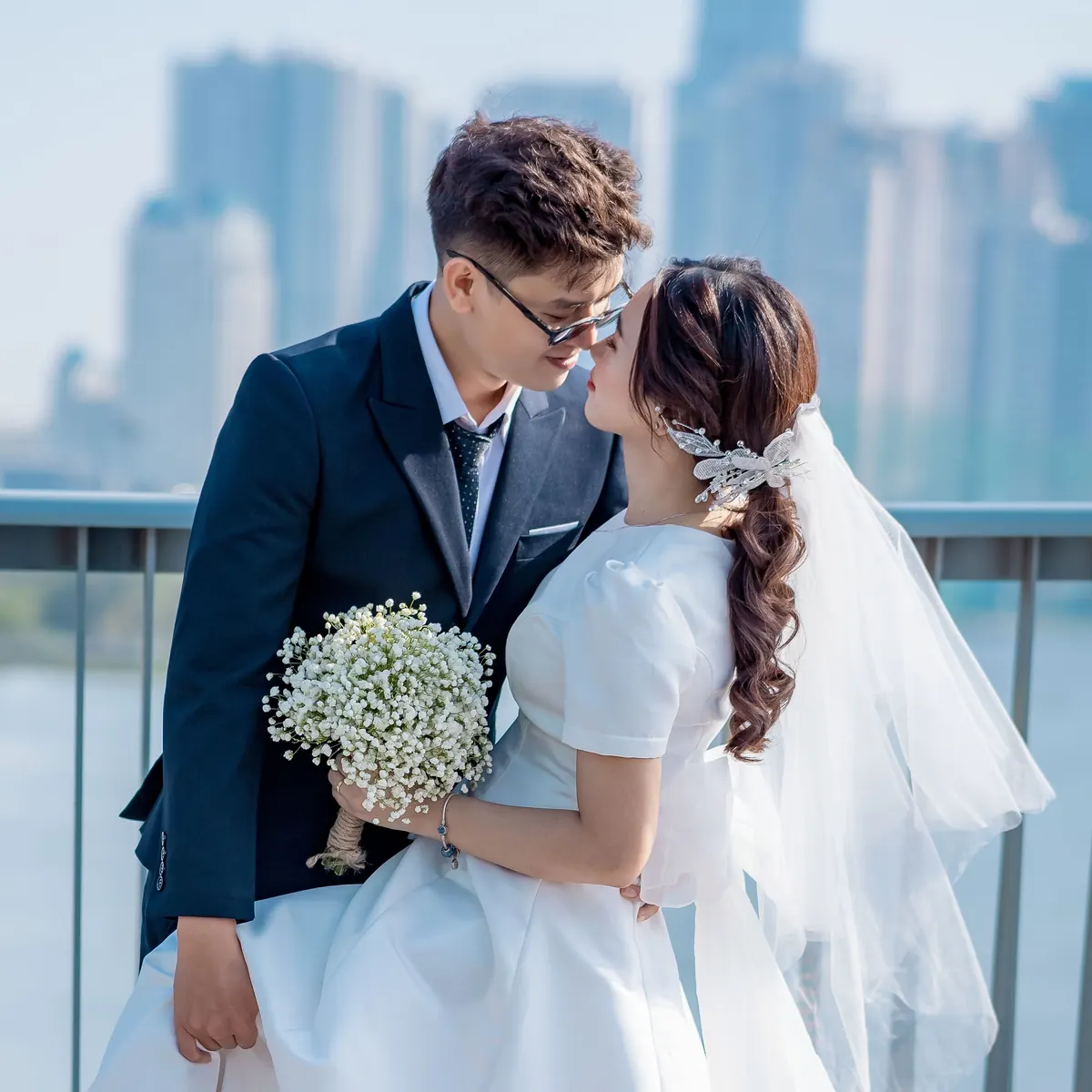 Khoa and Mai almost kissing, her veil catching the light, the bouquet in her hand