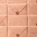 Rows of peach envelopes addressed by hand, each closed with a copper wax seal