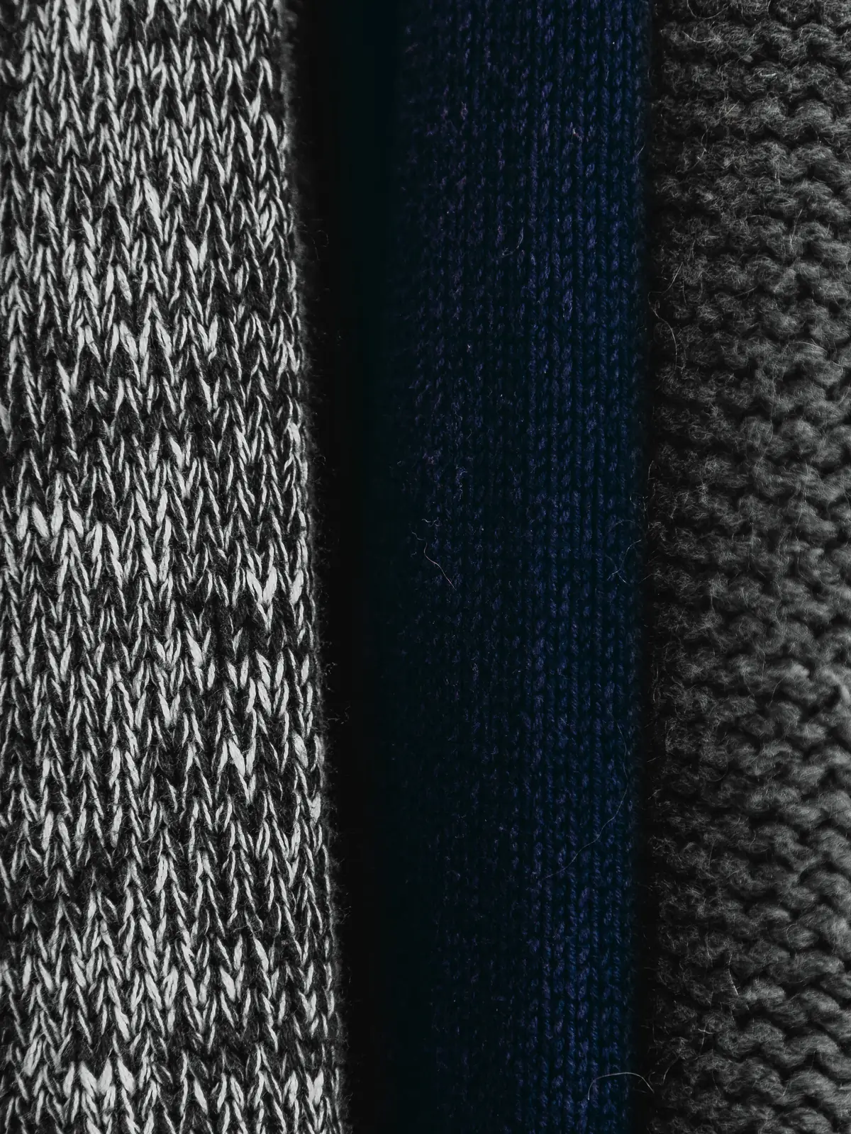Grey, navy and charcoal knitted fabrics side by side