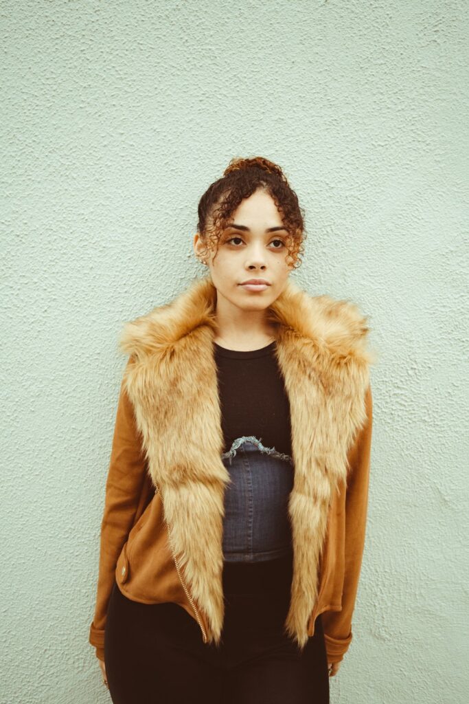 A woman in a camel faux fur gilet over a black top