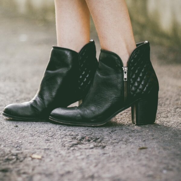 Black quilted ankle boots on a wet pavement