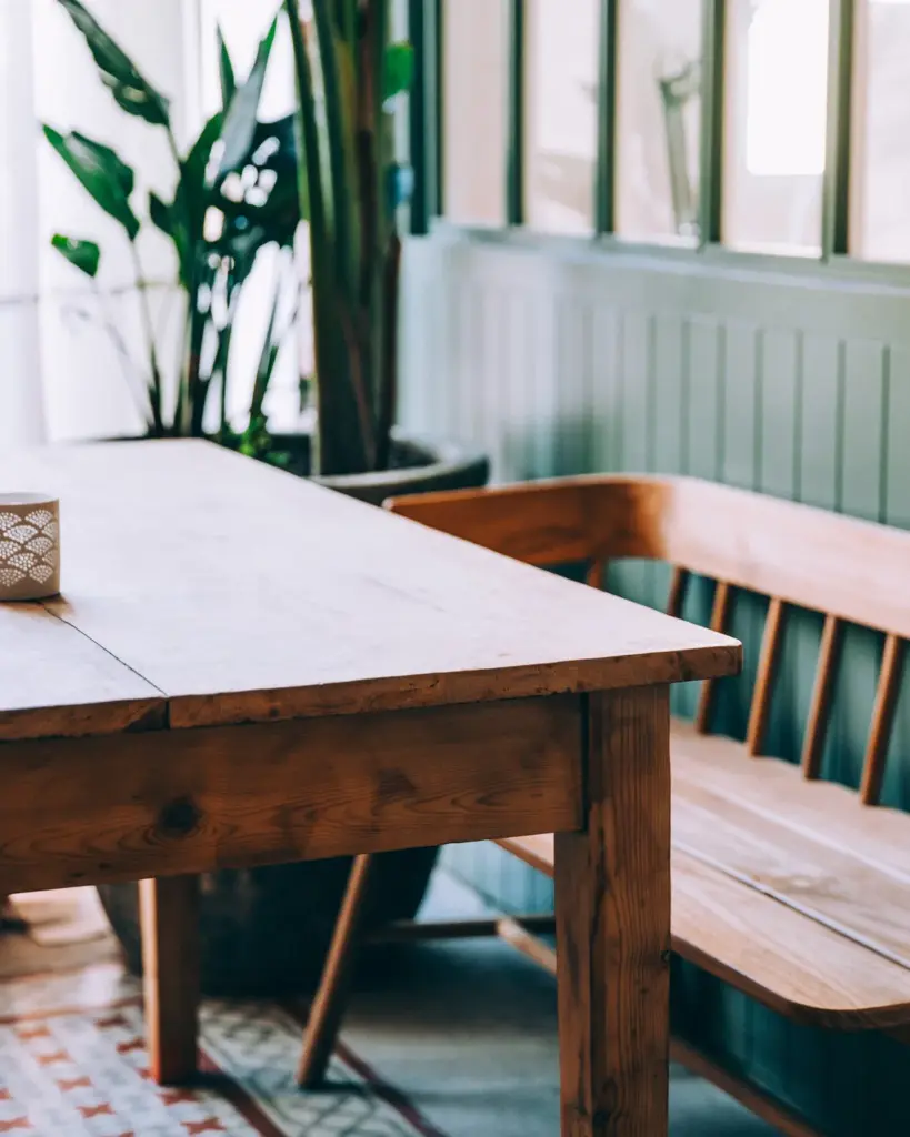 A long farmhouse table and bench against a green panelled wall