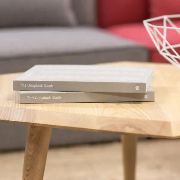 A hexagonal oak coffee table with books on it