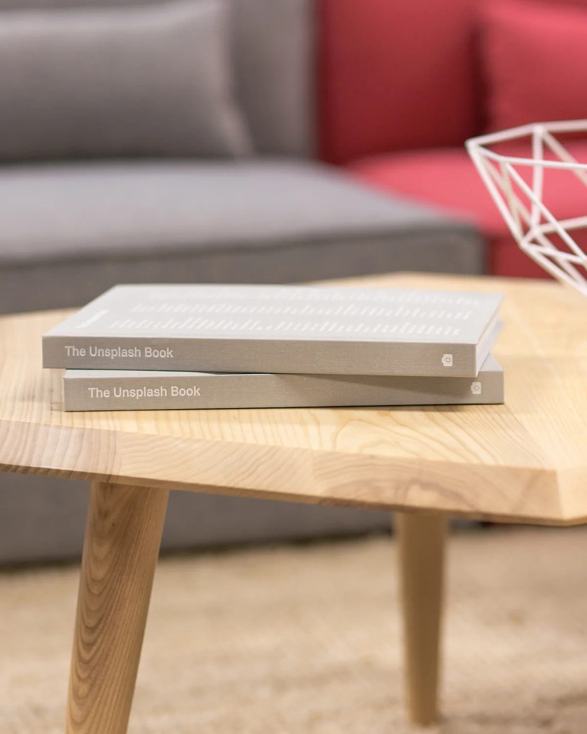 A hexagonal oak coffee table with books on it