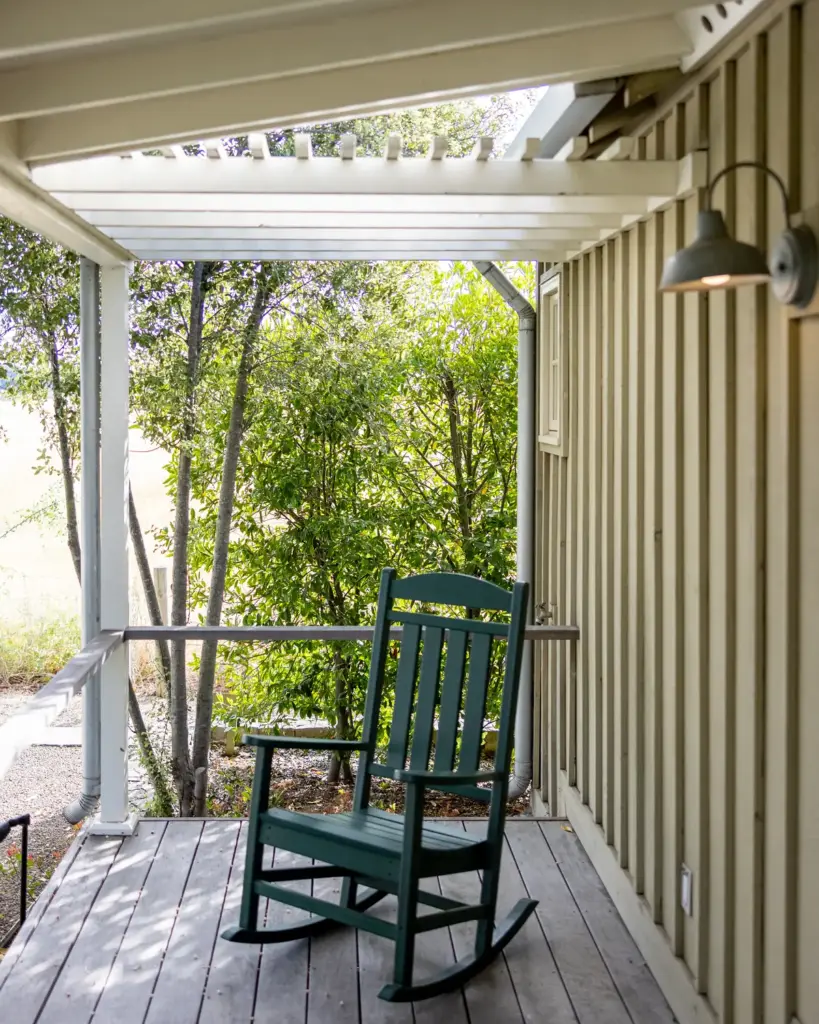 A painted rocking chair on a covered porch