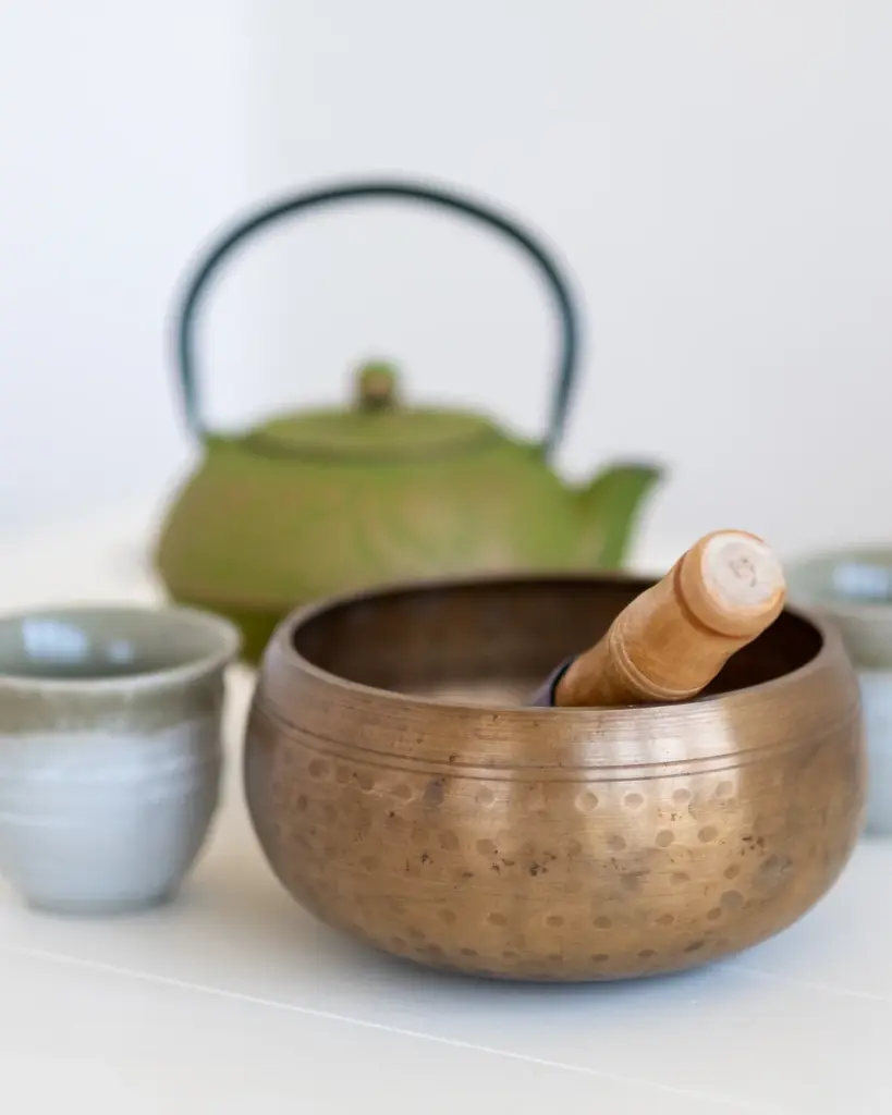 A green ceramic teapot with two cups and a bowl