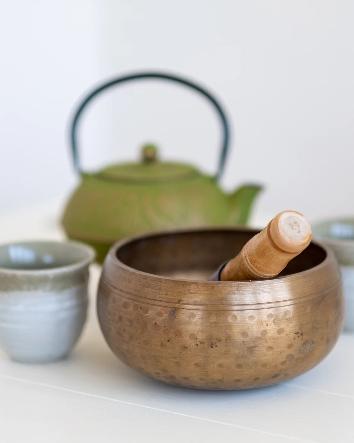 A green ceramic teapot with two cups and a bowl