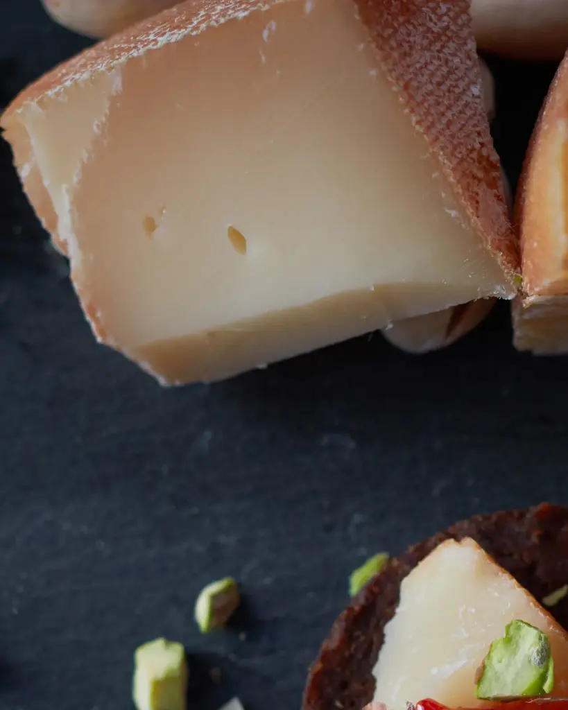A wheel of cheese with a wedge cut out of it