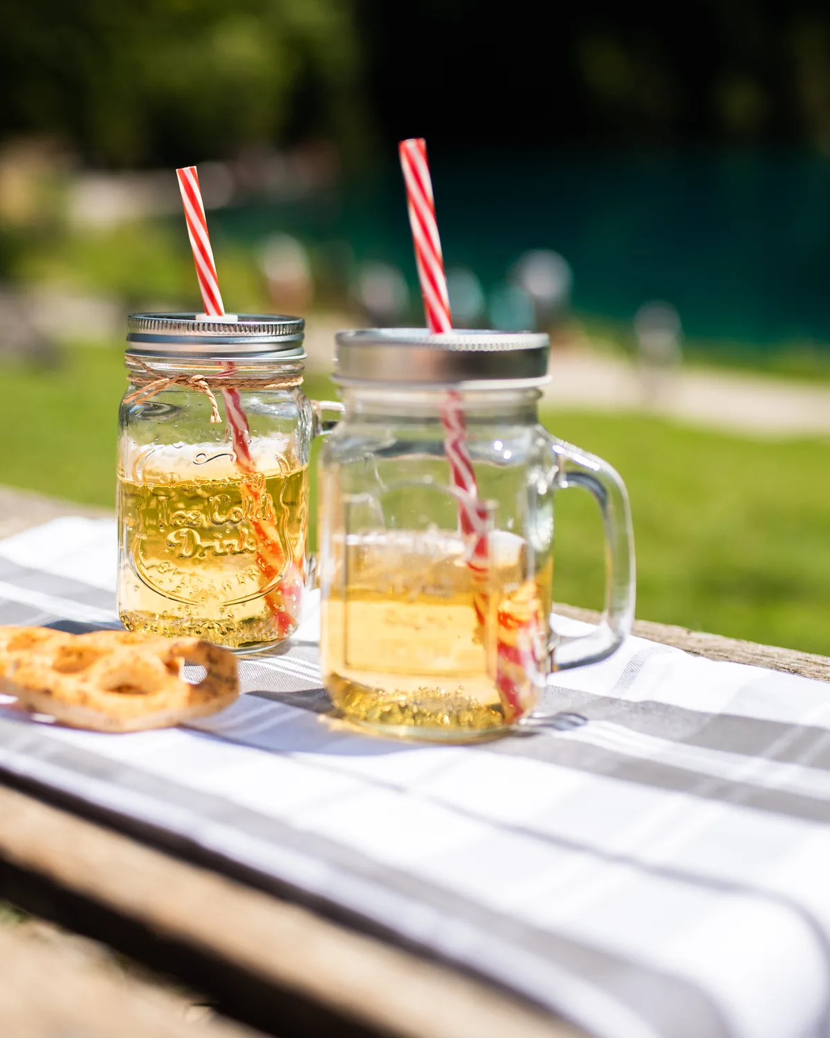 Two jars of iced lemon tea with straws, outdoors