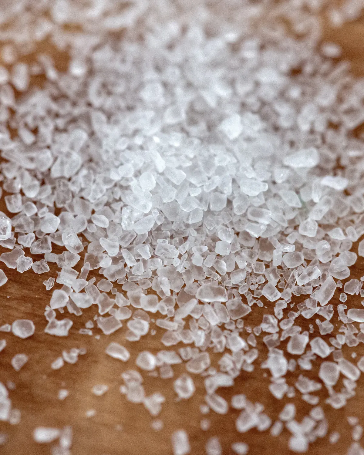 Coarse salt crystals scattered on wood