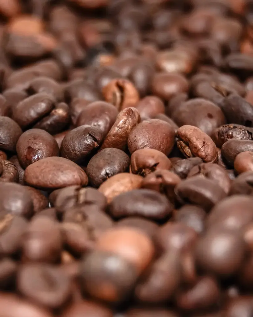 Medium-roast coffee beans filling the frame, tan and chocolate brown