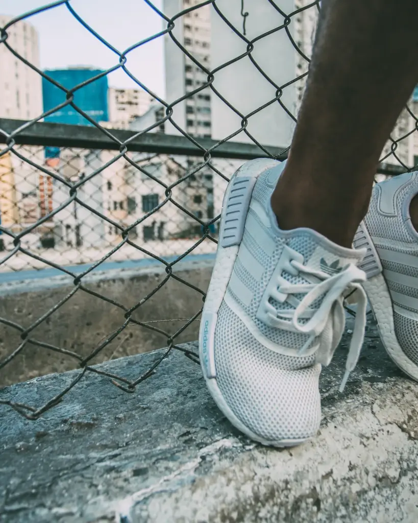 Pale blue mesh running shoes resting on a concrete ledge