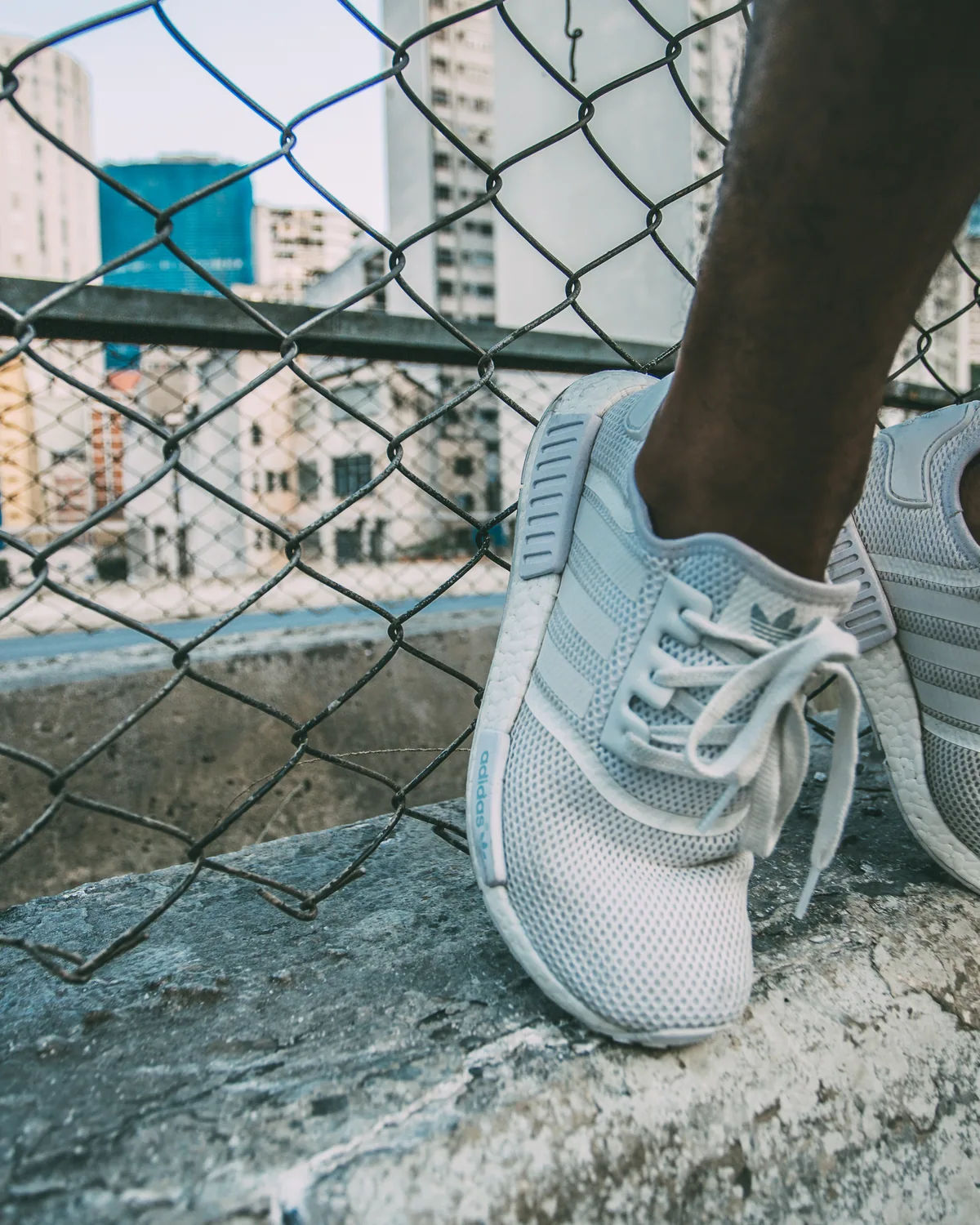 Pale blue mesh running shoes resting on a concrete ledge