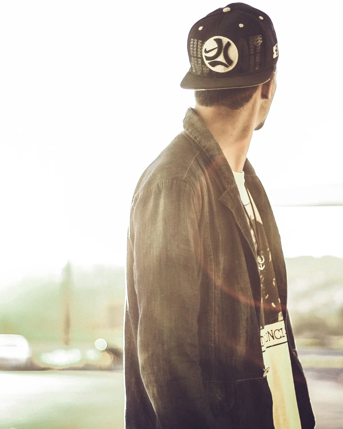 A person in a six-panel cap seen from the side in low sun
