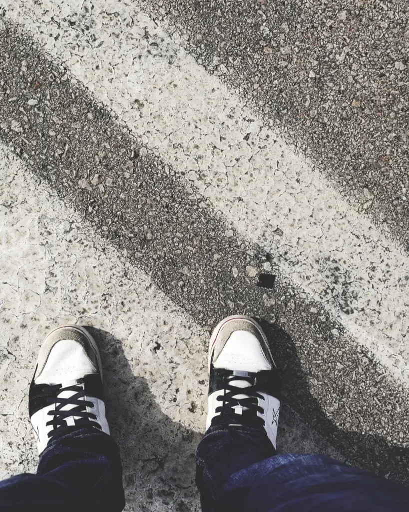 Black skate shoes seen from above on sunlit concrete