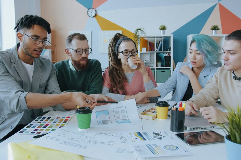 Five of the Northbank team around the studio table, going through colour swatches and printed layouts