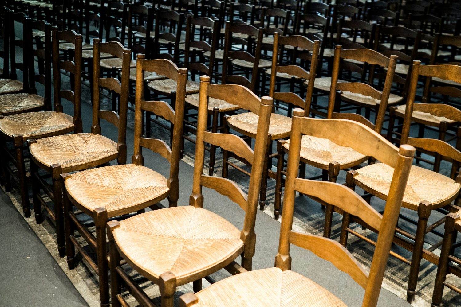 Rush-seated wooden chairs set out in rows in the hall at Riverside Church, waiting for a weekday group