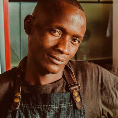 Kwame Boakye, ceramics tutor, in a denim work apron in warm workshop light