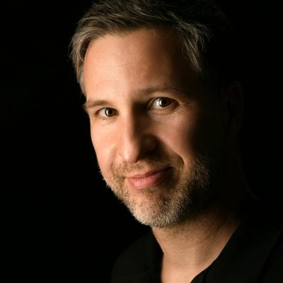 Joachim Reiss, author of The Long Rewrite, in a black shirt against a dark studio backdrop