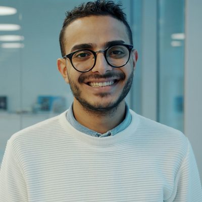 Idris Mahmood, financial planner at Ridgeway Advisory, smiling in glasses and a white jumper