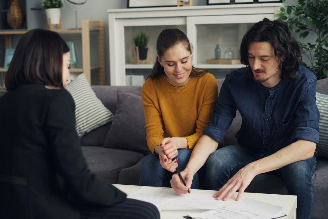 A Ridgeway Advisory planner going through a written plan with a couple over coffee-table papers