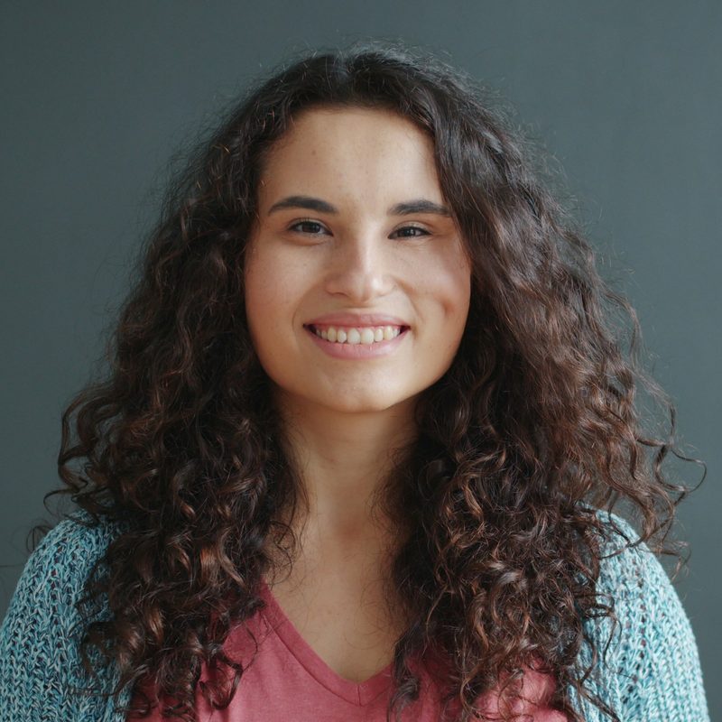 Sofia Marchetti, conditioning coach, smiling against a slate-grey wall
