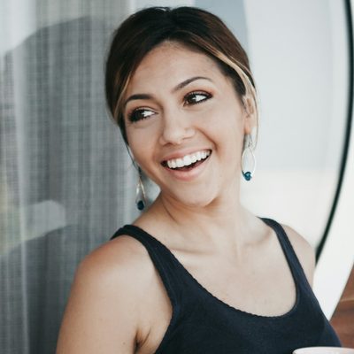 Priya Raman, a member for two years, smiling with a mug of tea after training