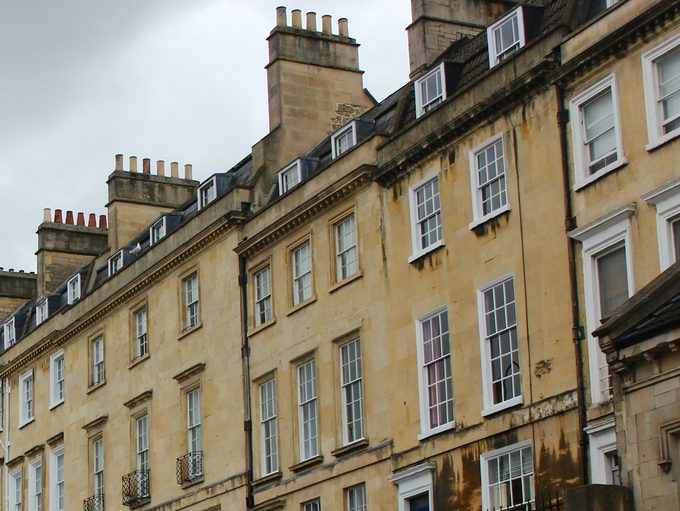 Upper floors and dormer windows of a Bath stone terrace, where the top-floor flat on Walcot Street sits