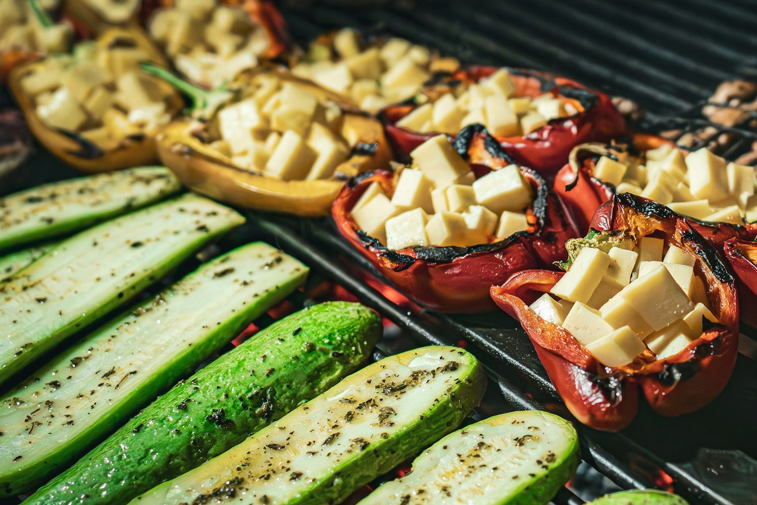 Split courgettes and stuffed peppers charring on the bars over glowing coals at Salt & Ember