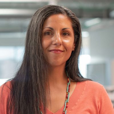 Priya Raman, Head of Product at Northwind, smiling in a bright open-plan office